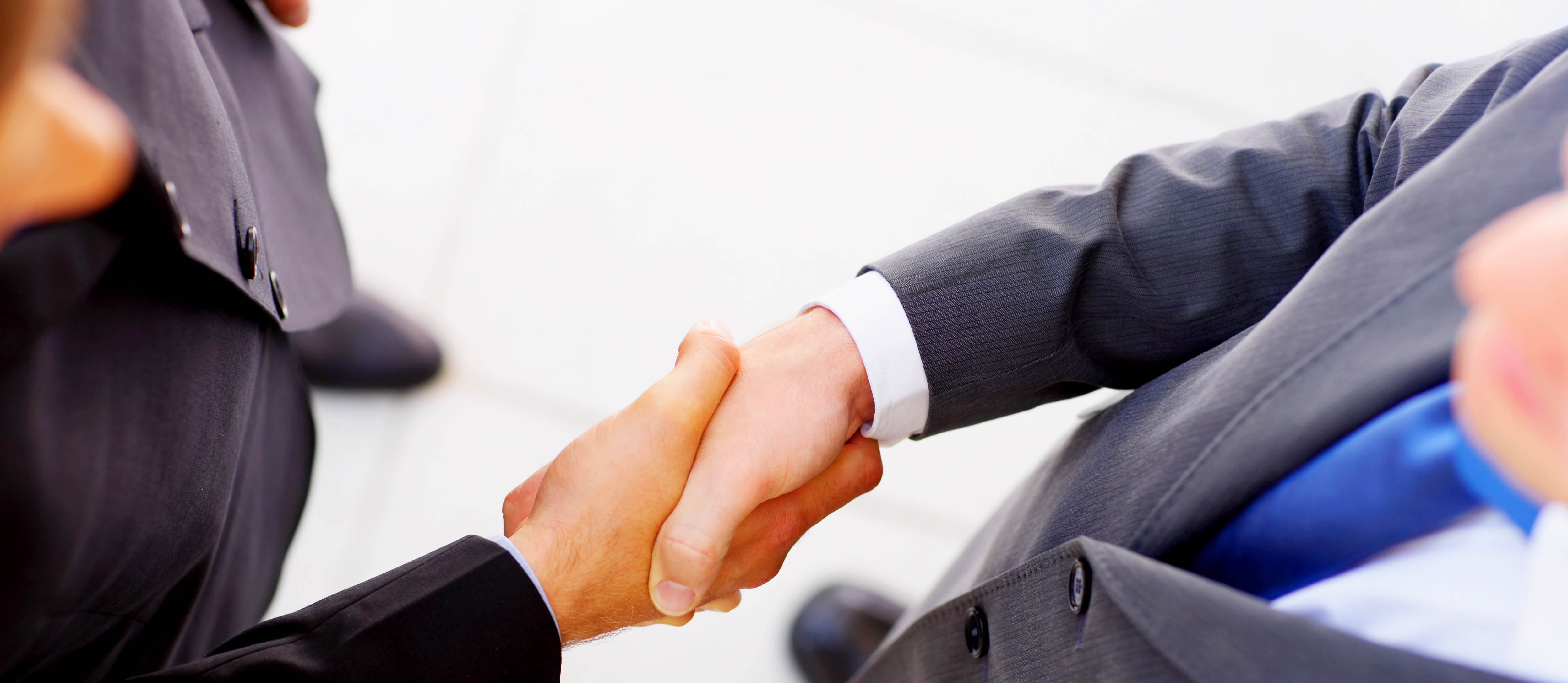 Businesspeople shaking hands, finishing up a meeting.