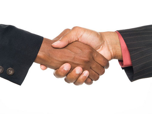 Isloated studio shot of a closeup view of an African American man and woman shaking hands to seal the deal.